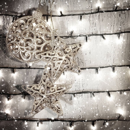Silver stars and bauble decor hanging on wooden grey background, glowing glitters, Christmas decor, New Year greeting cardの写真素材