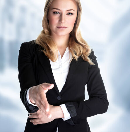 Closeup portrait of attractive business woman stretches out her hand for a handshake with partner, make a bargain, successful career conceptの写真素材