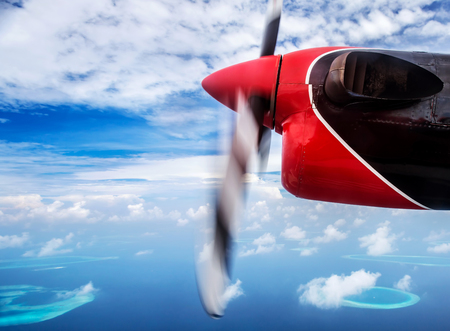 Summer traveling concept, small plane flying to the beach resort, scene destination, luxury aerial transport, tourism to exotic countryの写真素材