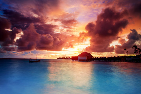 Sunset over Maldives islands, beautiful beach landscape, stunning evening seascape in orange sunset light, summer exotic holidays, travel and tourism conceptのeditorial素材