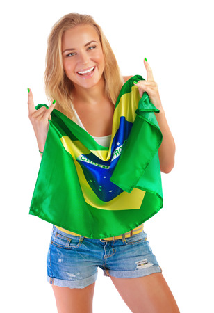 Happy football fan, beautiful blond girl holding in hands Brazilian national flag isolated on white backgroundの写真素材