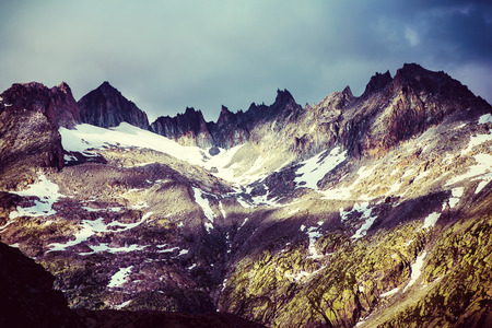 Majestic mountainous landscape, beautiful high Alps in summer covering with snow, grunge style...