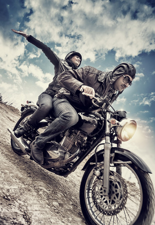 Active couple on motorcycle, happy woman riding with raised up hands with pleasure, enjoying speed, family in motorbike tour, grunge style photo
の写真素材