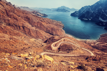 Beautiful landscape, curve road in dry arabian mountains over sea, exotic travel to the arab country, travel and tourism conceptの写真素材