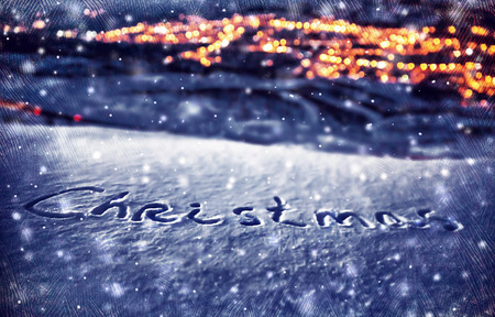 Snowy Christmas background, handwriting on the snow, beautiful winter nature at night, Xmas holidays theme, dark textured photo, selective focus on the textの写真素材