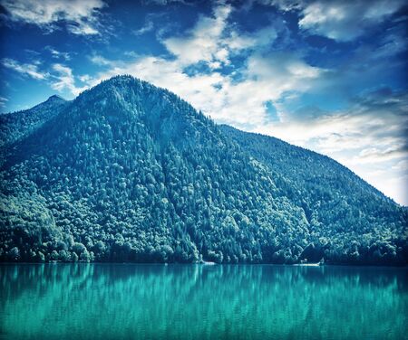 Beautiful landscape of great mountain covered with thick pine forest over lake, amazing panoramic scene of Alps, Austria, Europeの写真素材