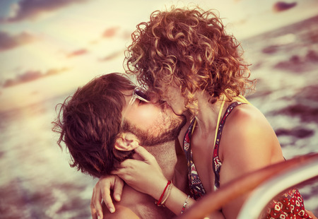 Closeup portrait of cheerful happy lovers kissing on sailboatの写真素材