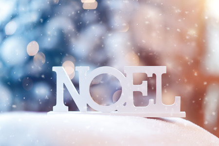 French Christmas wooden decoration, closeup photo of a wooden word Noel outdoors in snowy weather, happy Christmastime, beautiful New Year backgroundの写真素材