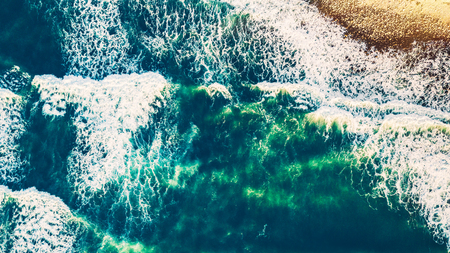 Bird's eye view on the open waters of planet earth, stormy seas, blue turquoise water of an ocean with waves and foam, abstract natural background, drone photographyの写真素材