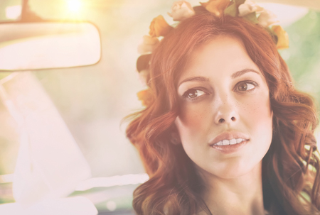 Closeup authentic portrait of a nice redhead female with freckles wearing floral wreath, natural beauty of Slavonian women, photo with bright sun flare
の写真素材