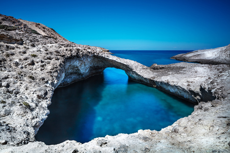 Beautiful sea landscape, amazing beauty of lagoon surrounded by rocks, transparent blue water bordered by a clear blue sky, summer in Milos, Greece, Europeの写真素材