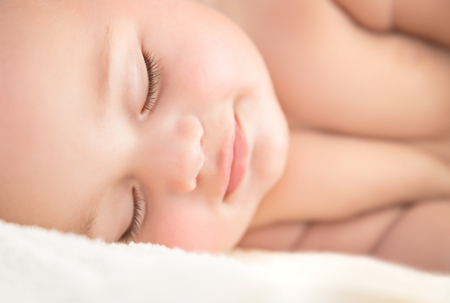 Closeup portrait of a cute sweet little baby sleeping, adorable infant napping, happy healthy childhood, new life conceptの写真素材
