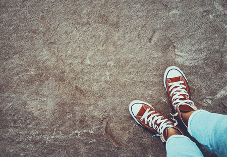 Photo of a red gumshoes over dirty sand background, cool teenagers shoes, urban youth lifestyle