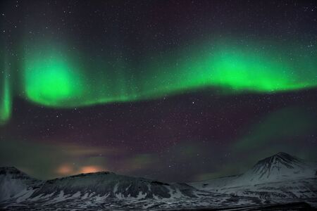 Amazing view on aurora borealis, magical green light glowing in the night sky, forces of nature, wonderful Icelandic landscapeの写真素材