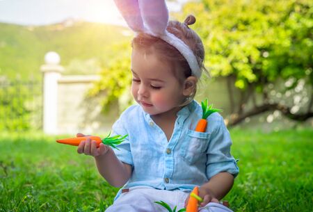 Portrait of a nice little boy with wonder looking on the carrotの写真素材