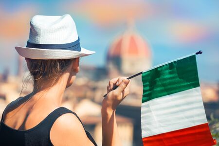 Photo of a woman tourist with the Italian flag enjoys the beautiful view on Florence architectureの写真素材