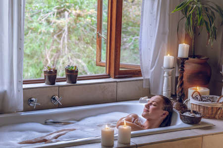 Pretty Female with Pleasure Taking Bath at Home with Foam and Salt. Time for Herself. Body Care....