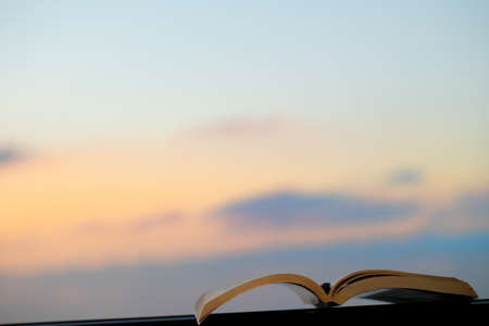 Spend a Nice Warm Evening Reading an Interesting Book Outdoors. Keep a Pen to Mark the Most Important Things. Calm Pleasant Pastime.の写真素材