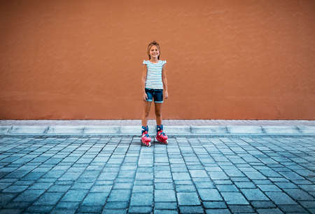 Cute Happy Little Girl Rollerblading in the Yard. Having Fun Outdoors. Perfect Summertime...