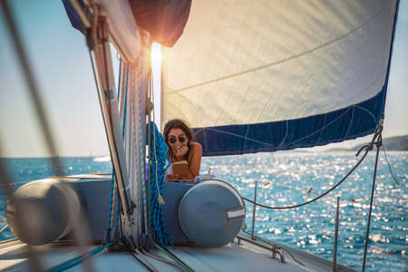 Pretty Woman Tanning on the Sailboat. Luxury Summer Trip to Greece. Recreation on Water Transport....
