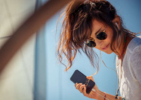 Traveler Girl with Pleasure Listening Music on the Sailboat. Enjoying Nice Melody. Luxury Summer Trip to Greece. Happy Holidays on the Yacht.の写真素材