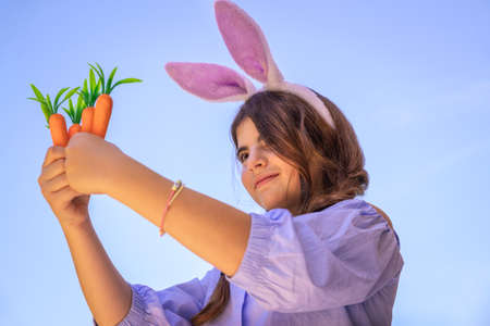 Portrait of a Little Girl Dressed as Bunny Playing with Carrots, Gardening and Having Fun Outdoors...