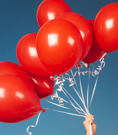 Closeup Photo of Many Red Balloons over Blue Sky Background. Happy Birthday Attribute. Festive Background.の写真素材