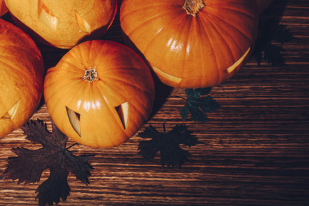Beautiful Stylish Halloween Still Life on Wooden Background. Carved Jack-o-lanterns Decoration with...