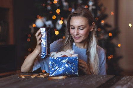 Portrait of a Happy Girl Enjoying Gifts at Home on Christmas Eve. Decorated Xmas Bokeh Tree Background. Happy New Year. Winter Holidaysの写真素材