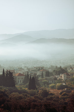 Beautiful View on a Small Mountainous Town in Morning Fog. Vertical Panoramic Landscape. Stunning Beauty of Lebanon.の写真素材