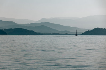 Sailboat in the sea with moutains landscapeの写真素材