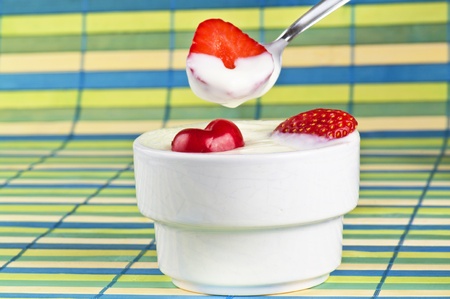 Yogurth in a spoon with strawberryの写真素材