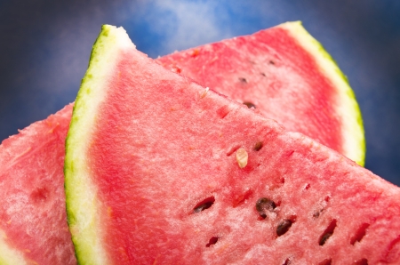 Close-up of red watermelon against the blue skyの写真素材