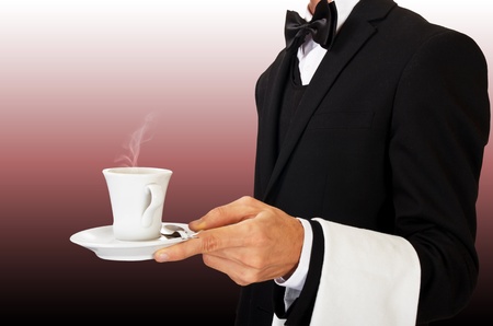 young waiter in uniform serving hot coffeeの写真素材