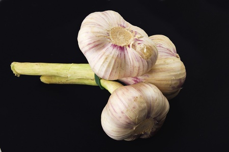 fresh garlic and two garlic cloves on the blackの写真素材