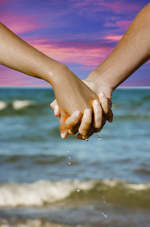 Couple of hands against the sea viewの写真素材