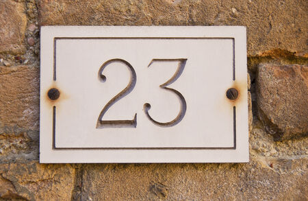 Brass Door Number 23 Mounted on Stone Facadeの写真素材