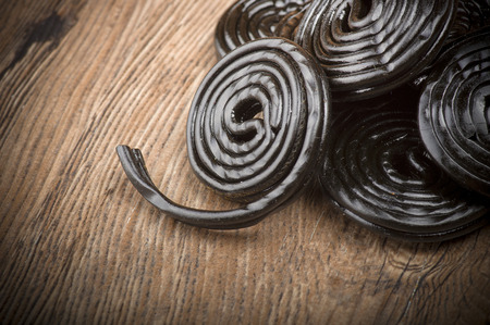 Licorice wheels candies close up on the woodの写真素材