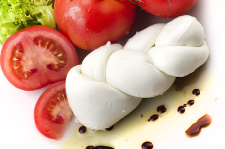 Mozzarella tomatoes and fresh salad on the whiteの写真素材