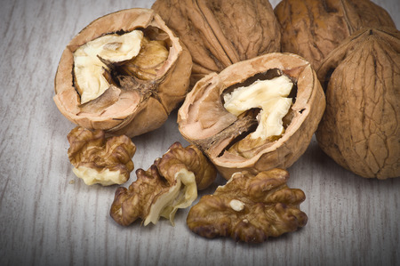 walnuts in shell and open on wood gray table