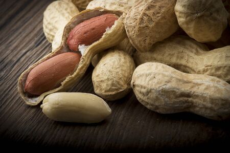 Peanuts in shells close up on the wood table