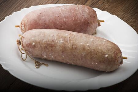 pork sausage (cotechino) with polenta on the wood tableの写真素材