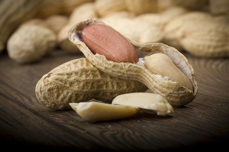 Peanuts in shells close up on the wood tableの写真素材