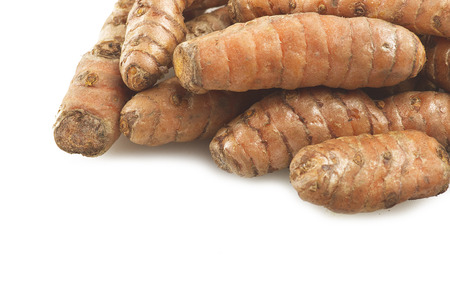turmeric root and some slices on a white background の写真素材
