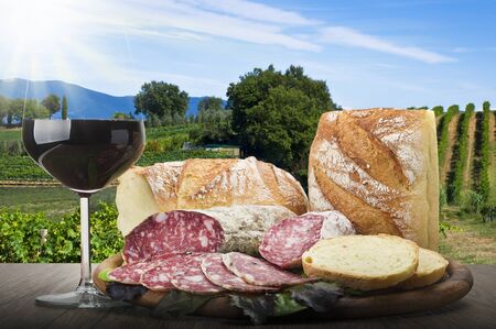 wooden cutting board with salami and glass of Red wineの写真素材