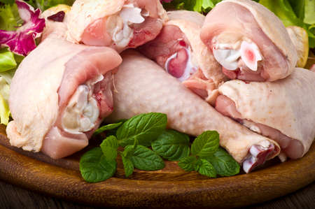 Fresh skinless chicken thighs and legs on cutting boardの写真素材