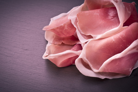 Raw ham leg sliced on the slateの写真素材