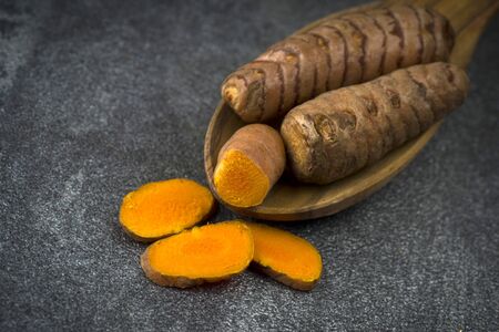 turmeric slices close up on gray background