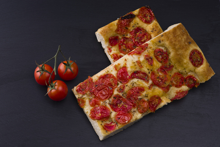 white pizza with tomatoes on the slate stone backgroundの写真素材