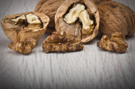 walnuts in shell and open on wood gray table  の写真素材